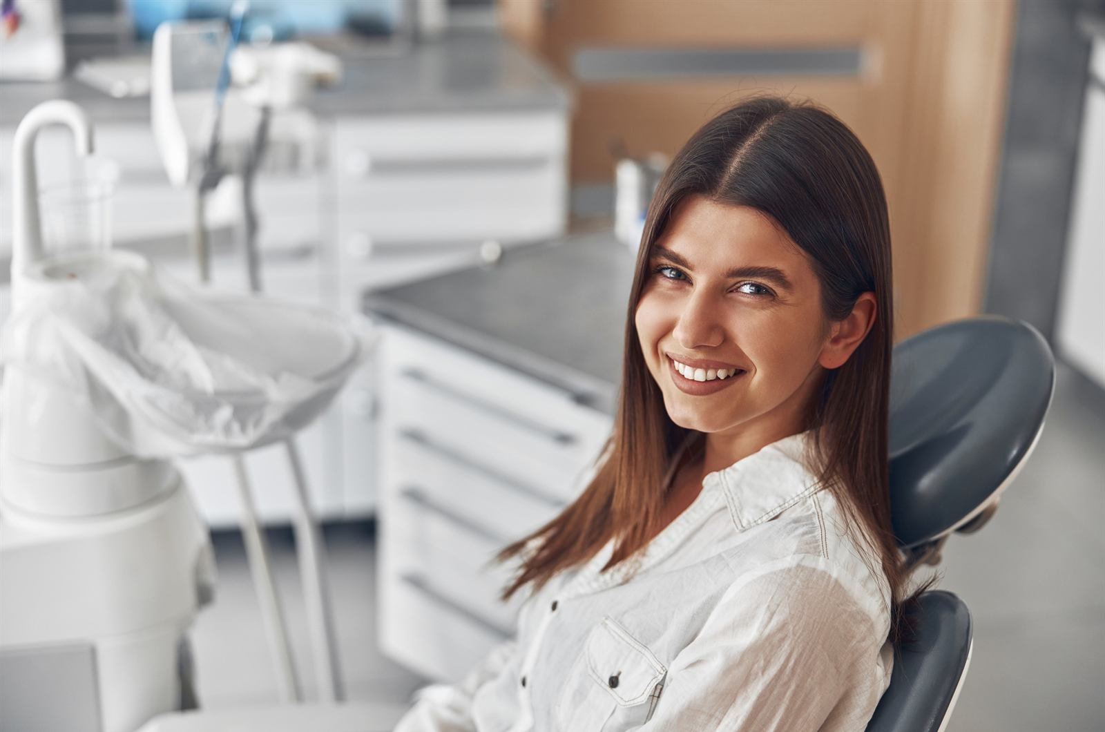 Mujer sonriendo en un consultorio dental moderno