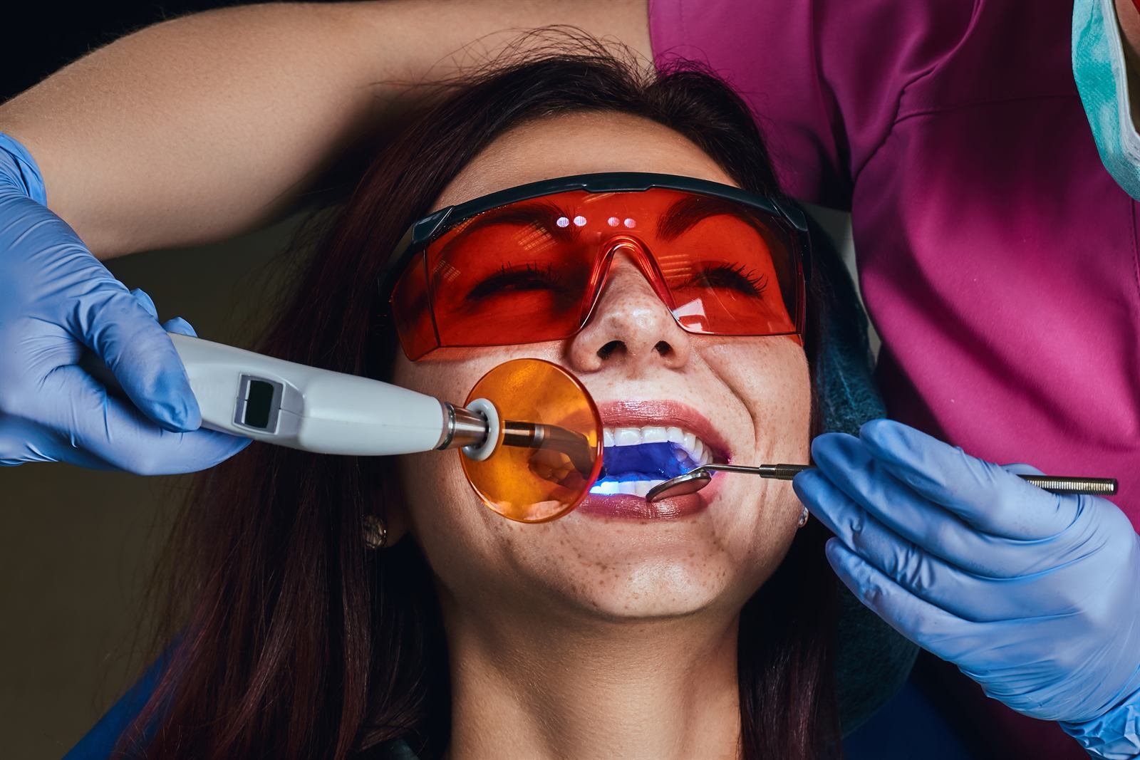 Paciente con gafas protectoras durante un blanqueamiento dental con luz LED